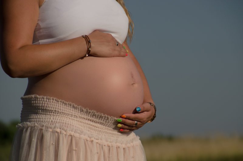 babybauch fotografie frau haelt babybauch outdoor