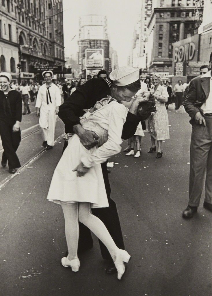 ein mann und eine frau kuessen sich auf dem time square in new york