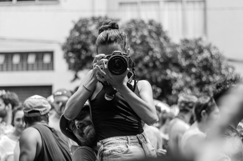 frau mit kamera wird hochgehoben um zu fotografieren