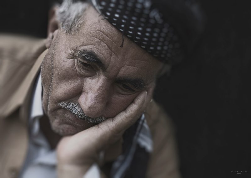 dokumentarfotografie eines alten mannes der den kopf auf seiner hand stuetzt