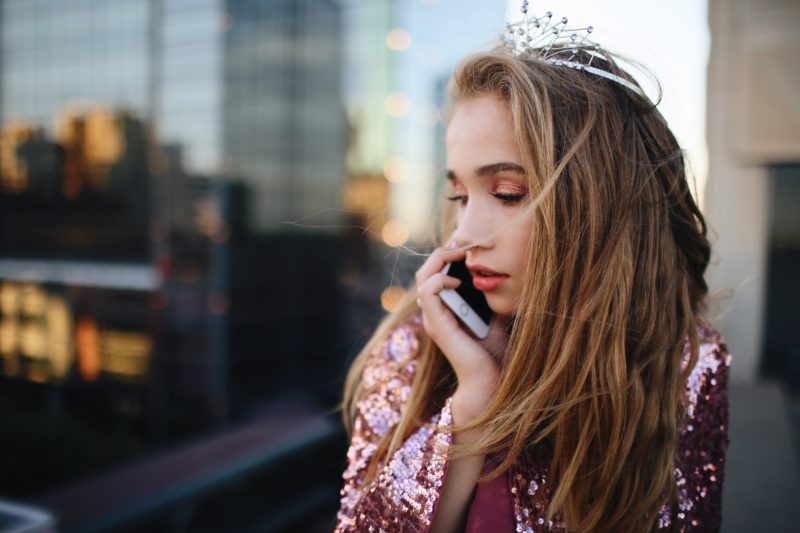 fashion model mit kroenchen und am telefon