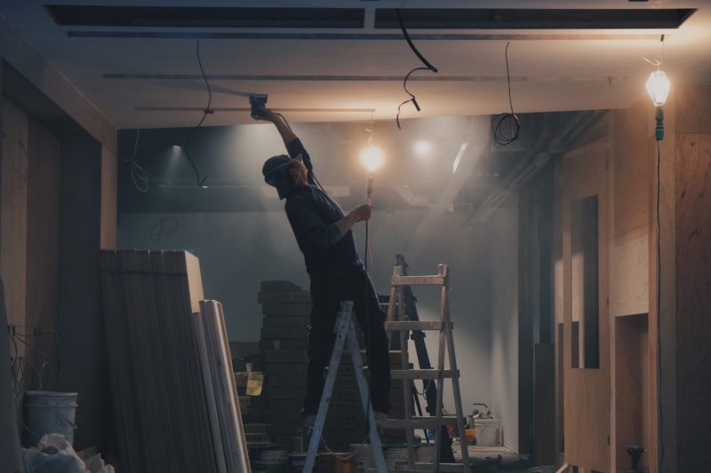 mann auf baustelle mit laterne zur beleuchtung