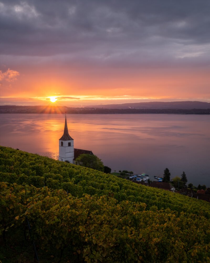 kleine kapelle am seeufer bei sonnenuntergang