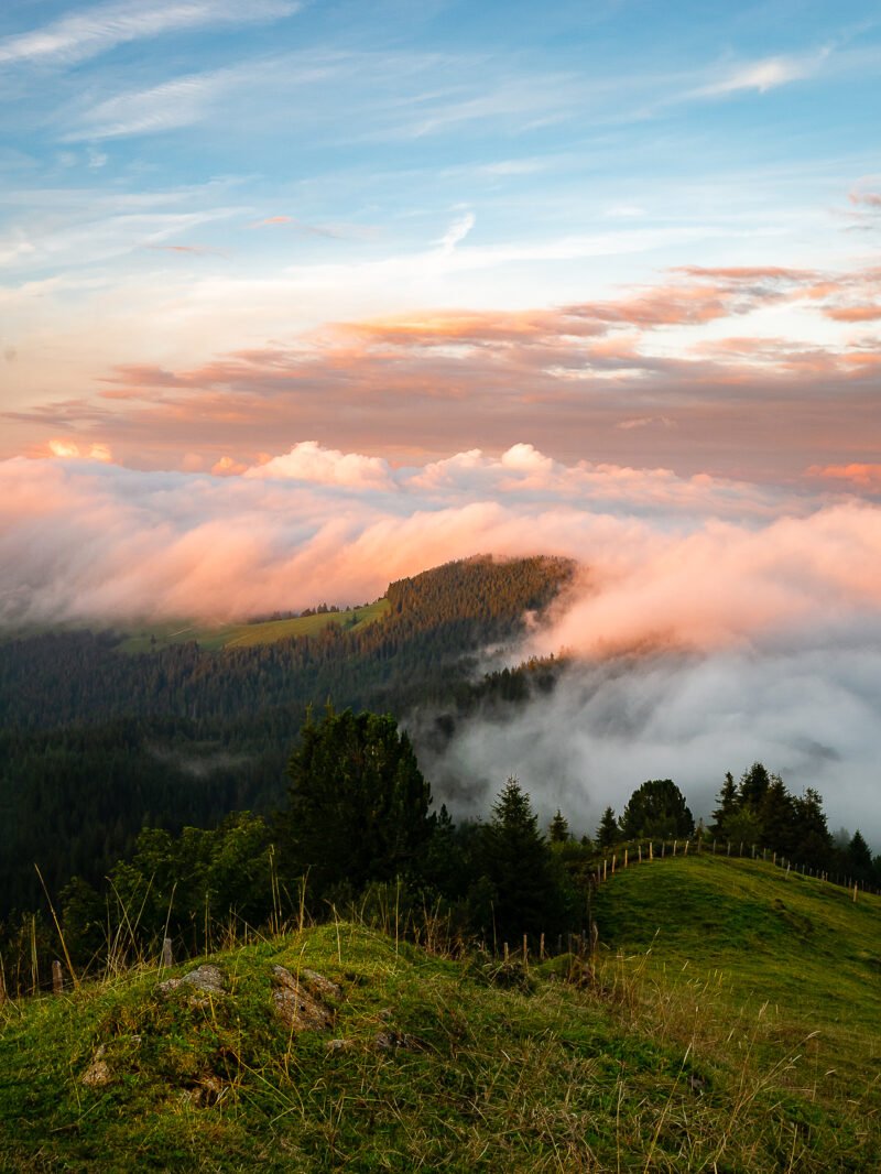 gruene huegellandschaft mit wolken bei sonnenuntergang