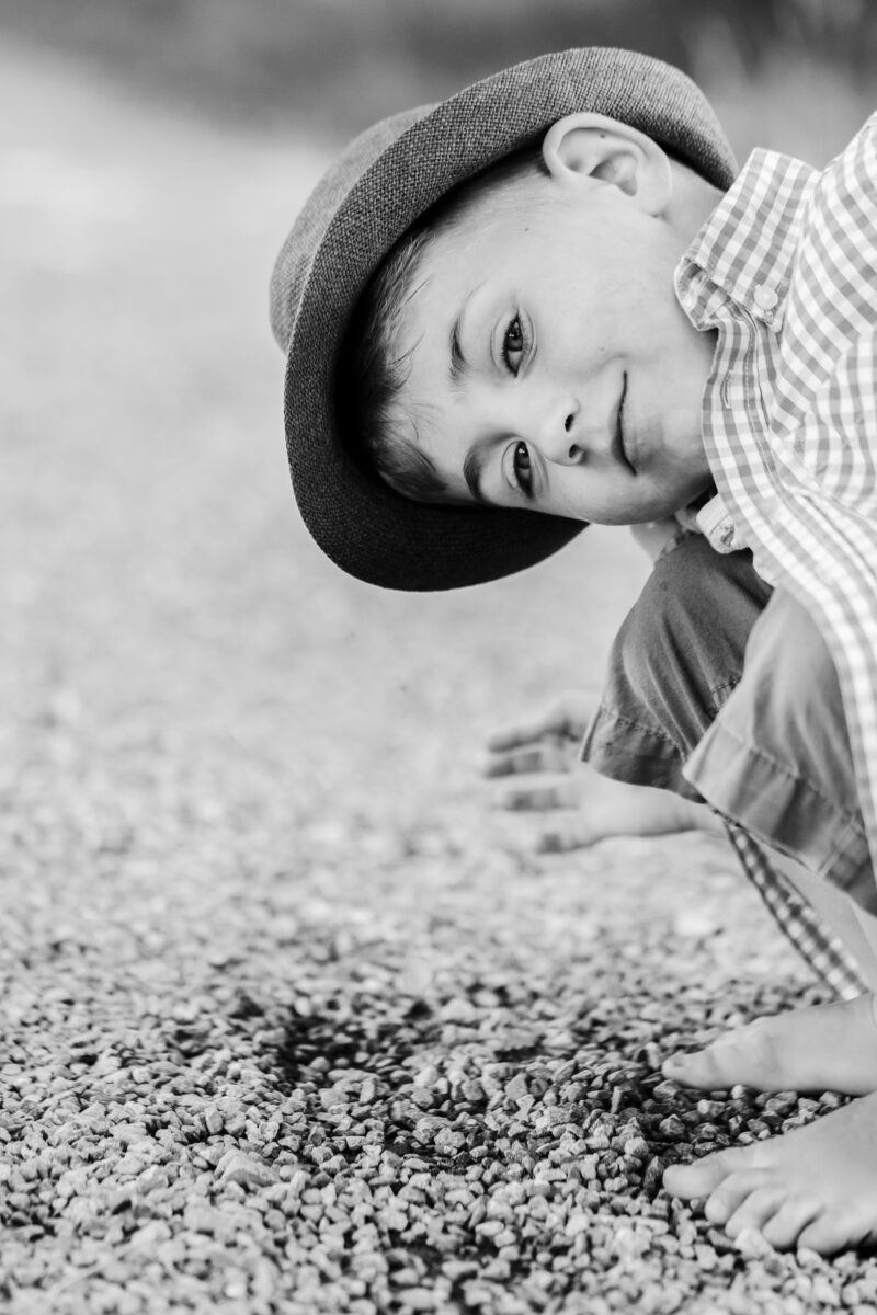 outdoorshooting mit kinder worin ein junge zur kamera schaut als schwarz-weiss foto