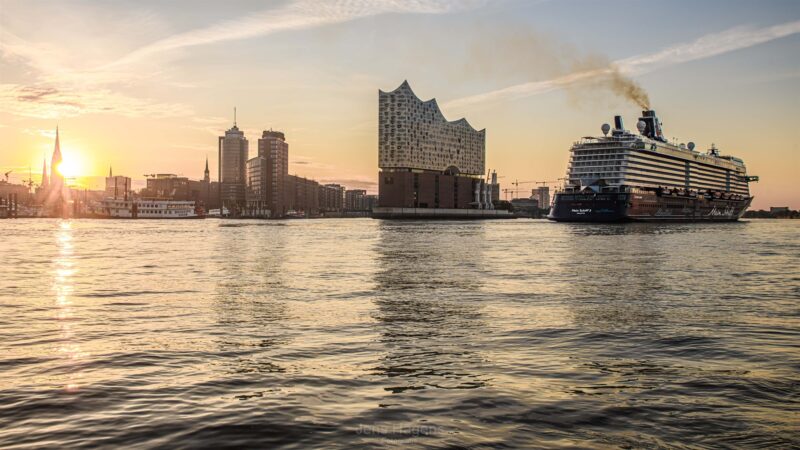 sonnenuntergang am hafen hamburg mit grossem schiff auf dem wasser