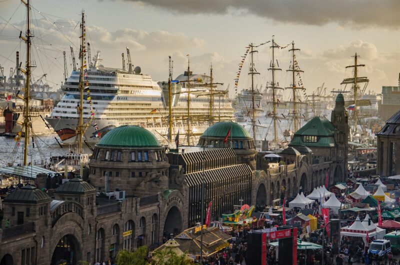 fotografie vom hafen mit einlaufendem kreuzfahrtschiff im hintergrund