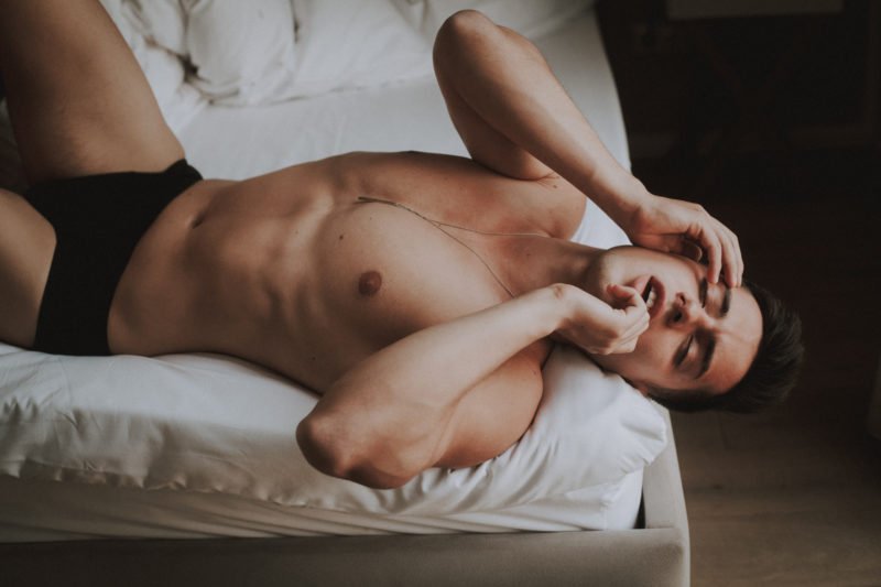 sensual male fotografie mann posiert sinnlich auf einem bett