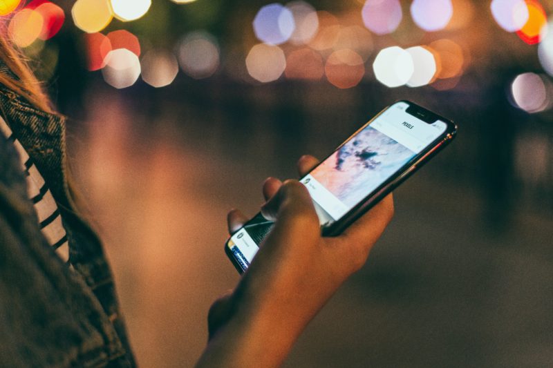 frau haelt telefon in der hand mit app fuer die stockfotografie